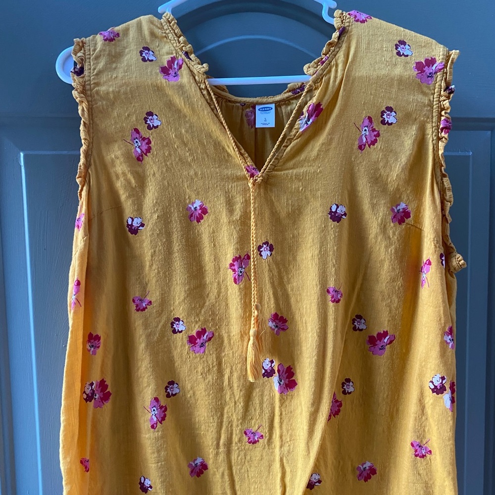 Adorable gold colored shirt with pink flowers.